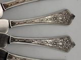 four spoons and a fork are sitting on a table