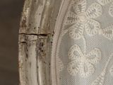 a close up of a white chair with a rust on it