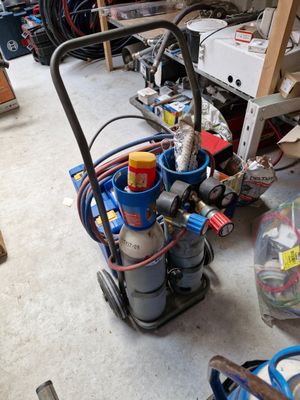 une image d'un garage avec de nombreux outils sur le sol