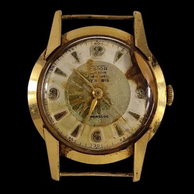 une image représentant un gros plan d'une montre en or sur fond noir