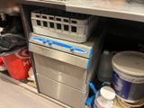 une cuisine où le plan de travail est encombré d'objets