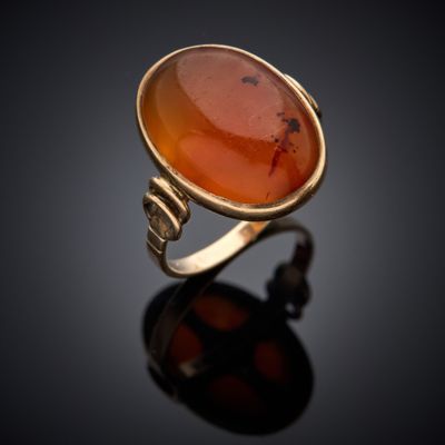 une bague en or ornée d'une pierre de cornaline au centre