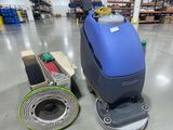 a blue machine sitting on top of a floor in a warehouse