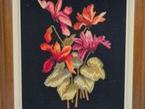 peinture représentant un bouquet de fleurs dans un cadre en bois sur fond noir