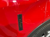 a close up of a red car with a sticker on it
