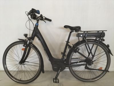 un vélo noir garé contre un mur blanc