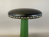 a green stool with a black leather seat on it