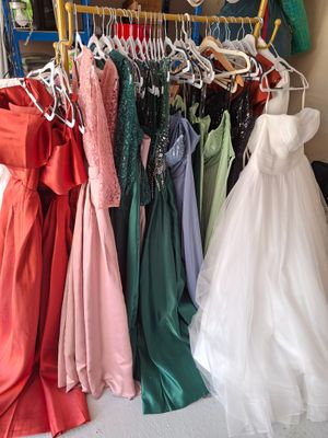 un grand nombre de robes suspendues à une étagère dans une pièce