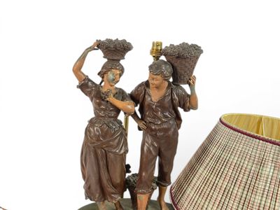 two figurines that are standing next to a lamp