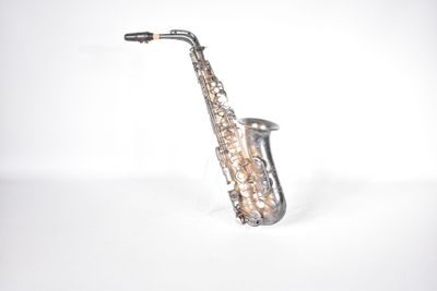 a silver saxophone that is sitting on a white surface