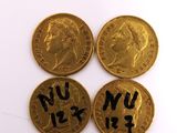 four gold coins with writing on them sitting next to each other