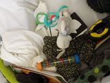a basket full of clothes and other items on a bed