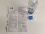 a bottle of water and a piece of paper on a table