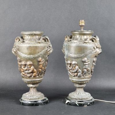 paire de vases anciens en argent reposant sur des socles en marbre, ornés de chérubins