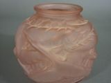 a pink glass vase with a leaf design on it