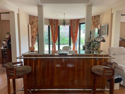 une photo d'un salon avec un bar au milieu