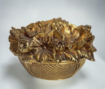 a gold bowl with a bunch of flowers in it
