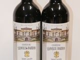 two bottles of wine sitting next to each other on a table