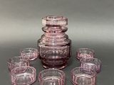 many glasses and a decanter sitting on a table