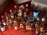 many bottles of alcohol sitting on a red cloth
