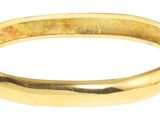 une image d'un gros plan d'un bracelet en or sur un fond blanc