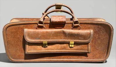 a brown suitcase sitting on a table with a handle on it