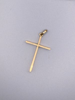 gros plan d'une croix en or sur une surface blanche