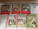 Plusieurs livres pour enfants sont alignés sur un lit
