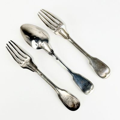 trois fourchettes et deux cuillères sur un plateau blanc