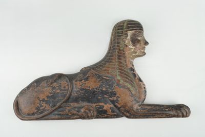 statue d'un sphinx couché sur une surface blanche, avec un fond blanc