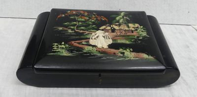 an image of a black box with a painting of a woman sitting on a bridge