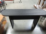 a black table with a black top in a warehouse
