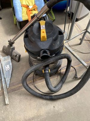 a vacuum that is sitting on the floor next to a chair