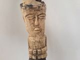 an image of a wooden sculpture of a man with a hat on his head