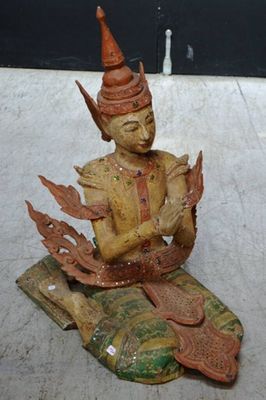 une petite statue représentant un homme assis sur un livre