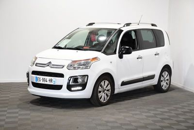 la petite voiture blanche est garée dans une pièce au sol à carreaux
