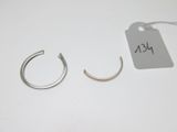 deux paires de boucles d'oreilles créoles en argent posées sur un fond blanc