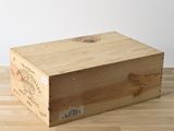 une caisse en bois sur laquelle est apposée une étiquette, posée sur un plancher en bois