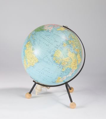 un globe bleu et jaune posé sur un socle en bois