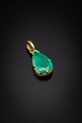 un pendentif en forme de larme couleur émeraude sur fond noir
