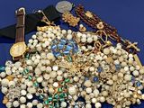 un tas de bijoux posés sur une surface bleue, avec une montre