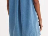 the back view of a woman in a blue denim dress and white socks