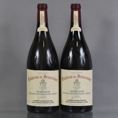 two bottles of red wine sitting on top of a table