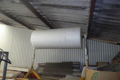 un gros rouleau de papier posé sur une palette dans un entrepôt
