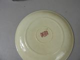 a white plate with a red spot on it on a table