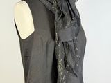 gray sleeveless dress with a black neck tie and a black dress