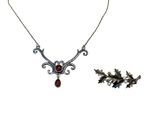 une image représentant un collier et une broche sur fond blanc