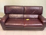 a brown leather couch with a yellow tag on it