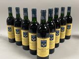 six bouteilles de vin sont alignées sur une surface blanche