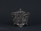an antique silver plated sugar dish on a black background